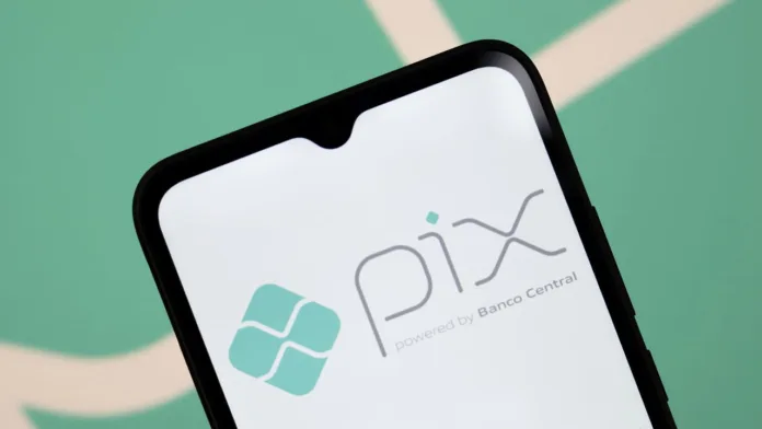 Imagem de um smartphone exibindo a logo do Pix, sistema de pagamentos instantâneos desenvolvido pelo Banco Central do Brasil. O fundo da foto é verde, com detalhes suaves que destacam o aplicativo na tela do dispositivo.