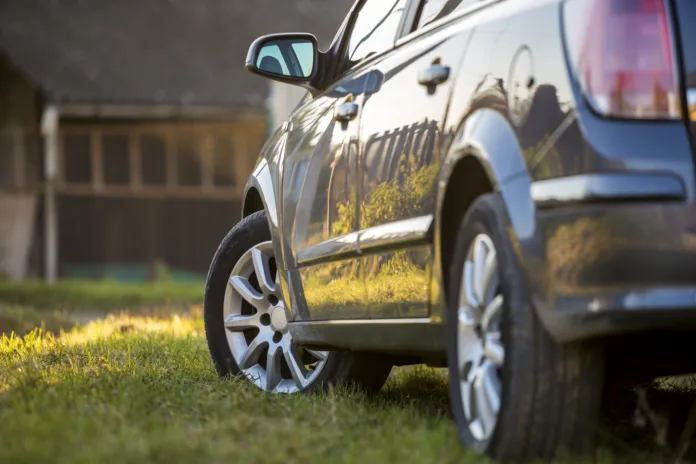 Carro seminovo estacionado em área rural com gramado, representando compras de veículos online. Imagem ilustrativa para matéria sobre golpe virtual em transações financeiras via Pix.