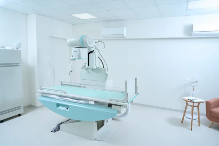 Sala de raio-X com equipamento médico moderno. Imagem ilustrativa para matéria sobre adicional de periculosidade para profissionais expostos à radiação ionizante.